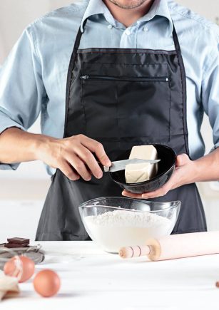 Homem a cortar um pedaço de manteiga para utilizar para cozinhar